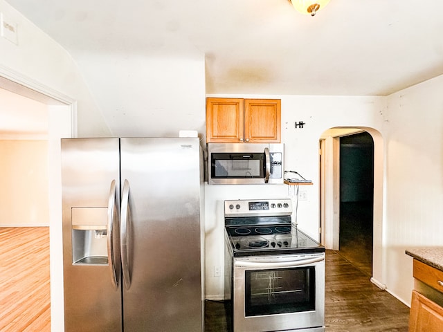 kitchen with stainless steel appliances and dark hardwood / wood-style floors