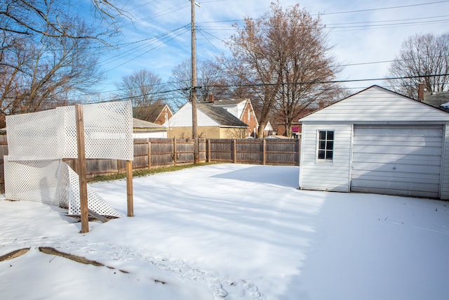 yard covered in snow with a garage and an outdoor structure