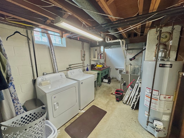 basement featuring washing machine and clothes dryer, sink, and water heater