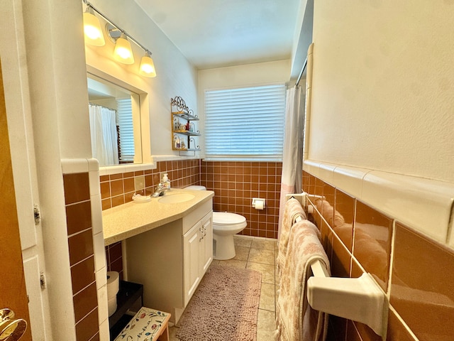 bathroom featuring vanity, toilet, tile patterned flooring, and tile walls