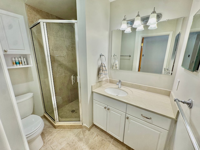 bathroom with vanity, a shower with door, and toilet