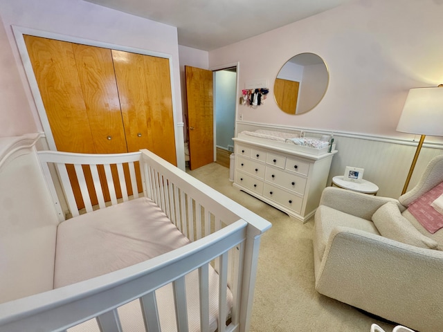 carpeted bedroom with a nursery area and a closet