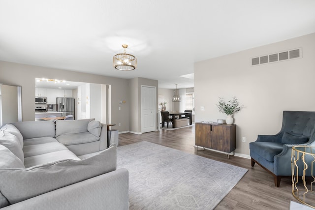 living room featuring an inviting chandelier and light hardwood / wood-style floors