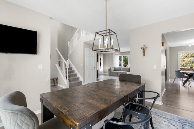 dining space with hardwood / wood-style flooring and a notable chandelier