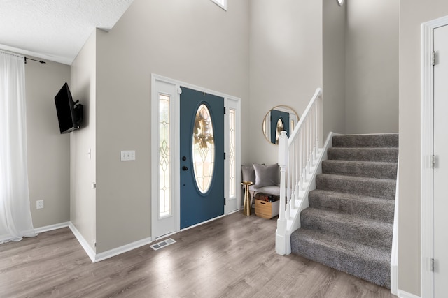 entrance foyer with hardwood / wood-style floors and a textured ceiling