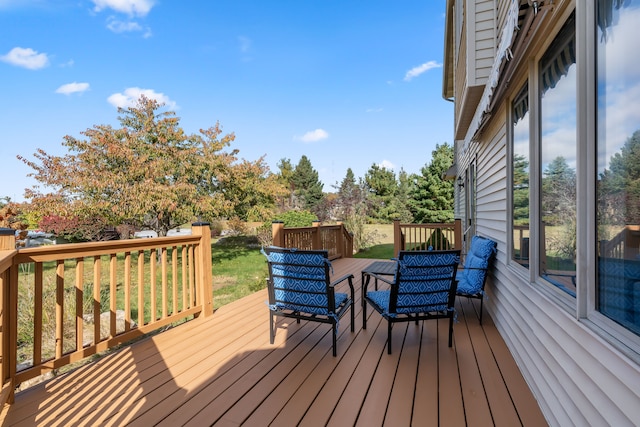 wooden deck featuring a lawn