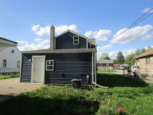 back of house featuring a yard and central air condition unit