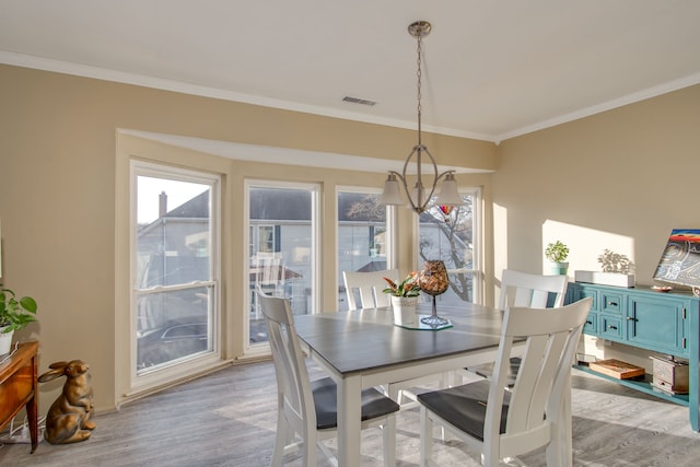 dining area featuring light hardwood / wood-style flooring and ornamental molding