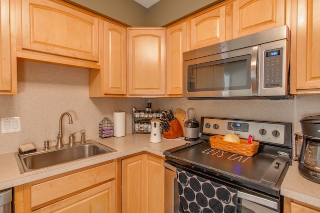 kitchen with sink, backsplash, light brown cabinets, and appliances with stainless steel finishes