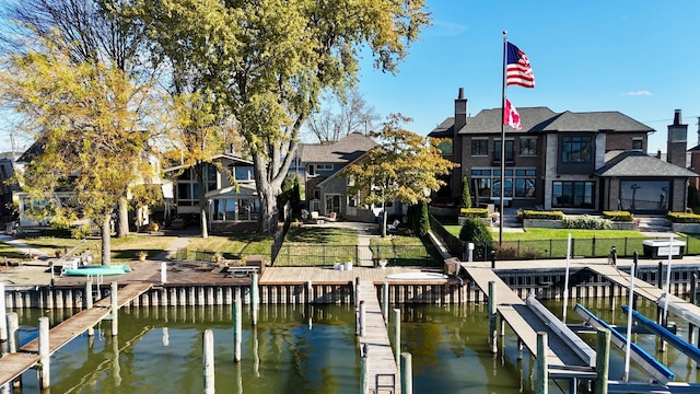 view of dock with a water view and a lawn