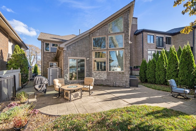 rear view of property with a patio and an outdoor fire pit