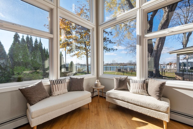 sunroom / solarium featuring a baseboard radiator and a healthy amount of sunlight