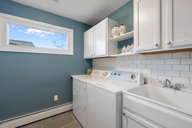 clothes washing area featuring baseboard heating, independent washer and dryer, sink, and cabinets