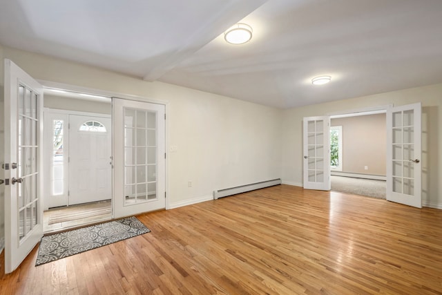 entrance foyer featuring light hardwood / wood-style floors, baseboard heating, and french doors