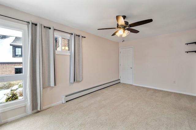 empty room featuring ceiling fan, a baseboard radiator, light carpet, and a wealth of natural light