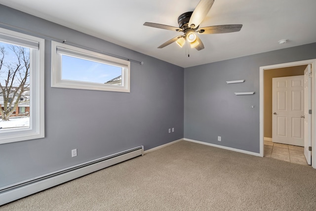 empty room featuring a baseboard heating unit, light colored carpet, and ceiling fan