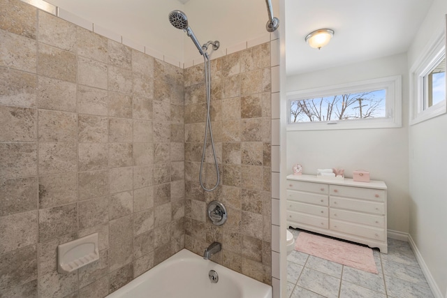 bathroom featuring toilet and tiled shower / bath