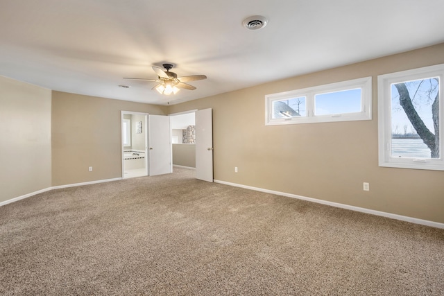 unfurnished bedroom with ensuite bathroom, ceiling fan, and carpet