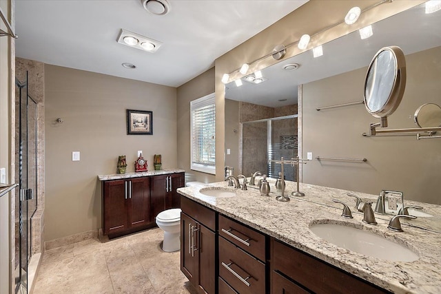 bathroom featuring a shower with door, vanity, tile patterned floors, and toilet