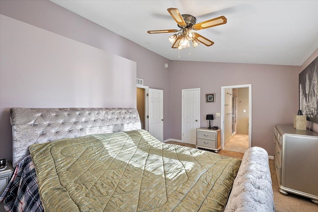 bedroom with vaulted ceiling, light colored carpet, and ceiling fan