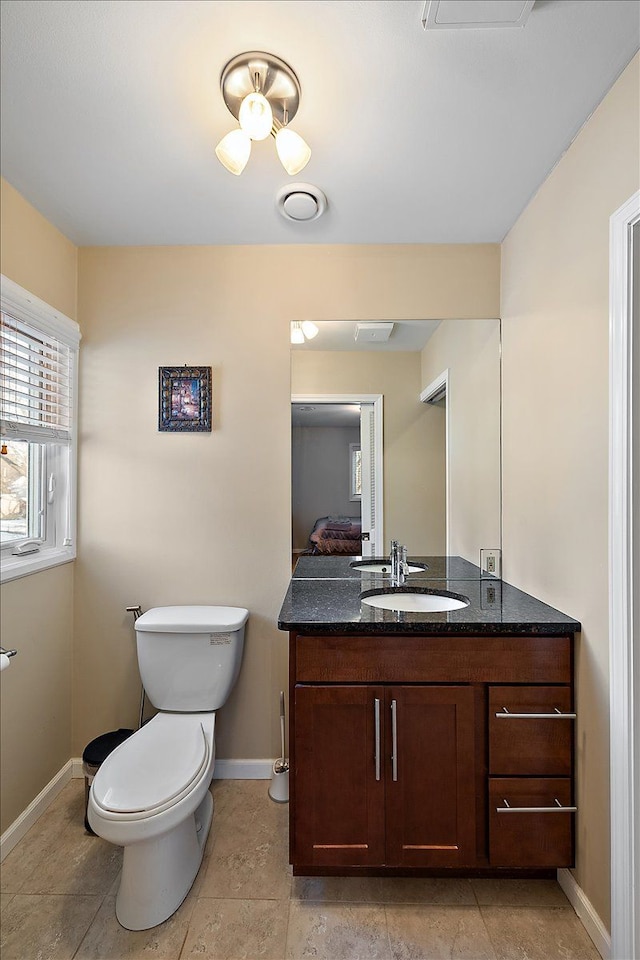 bathroom with tile patterned flooring, vanity, and toilet