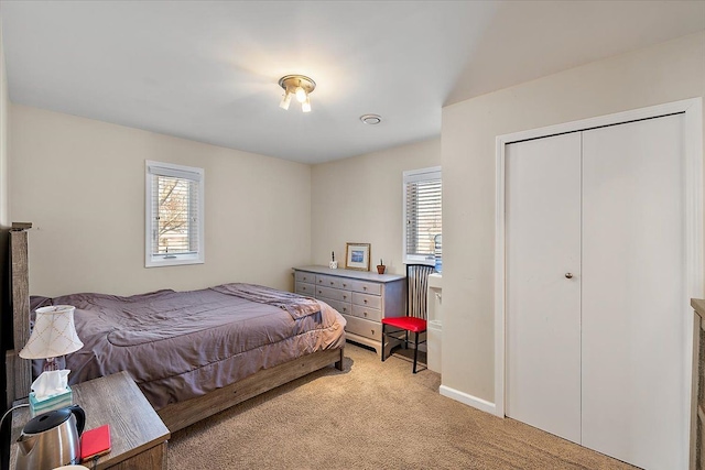 bedroom featuring light colored carpet and a closet