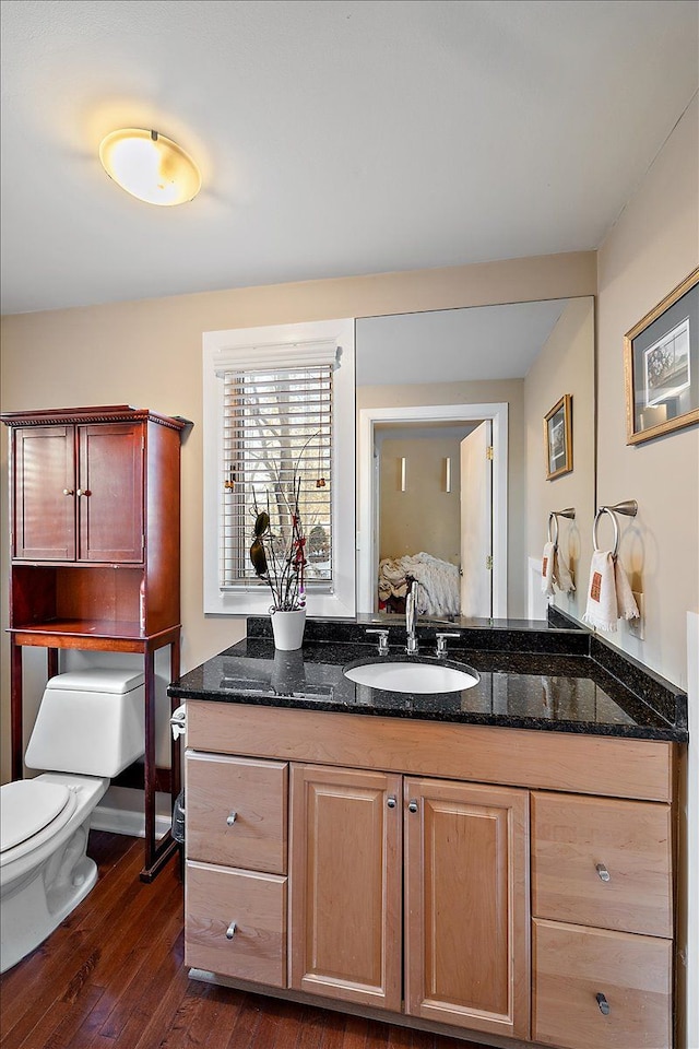 bathroom featuring vanity, toilet, and hardwood / wood-style floors