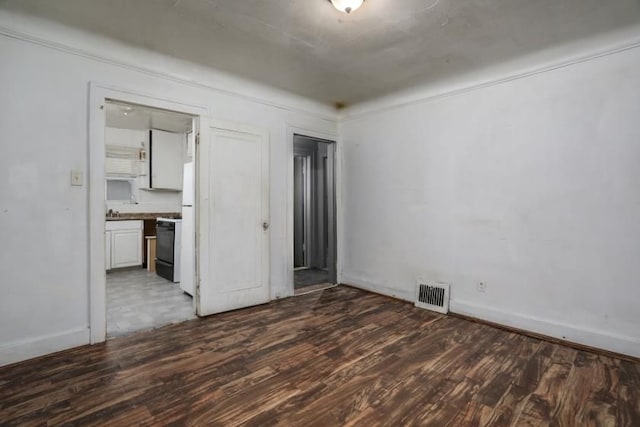 empty room with dark hardwood / wood-style flooring