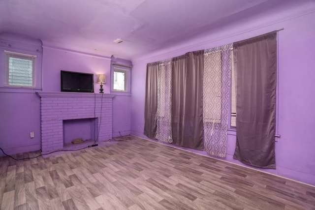 unfurnished living room featuring a fireplace and light hardwood / wood-style floors