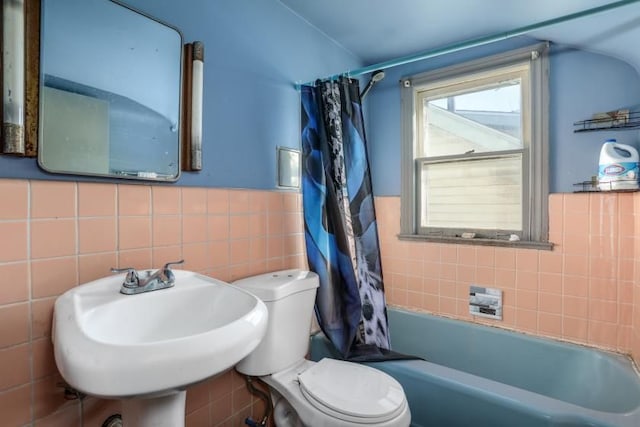 full bathroom featuring shower / bathtub combination with curtain, sink, tile walls, and toilet