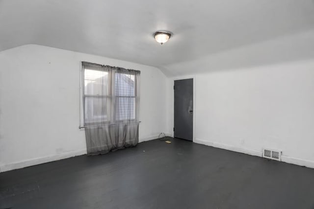 empty room featuring lofted ceiling