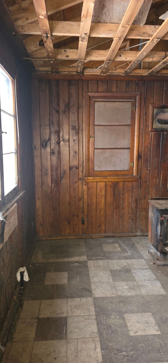 basement with a wood stove and wood walls