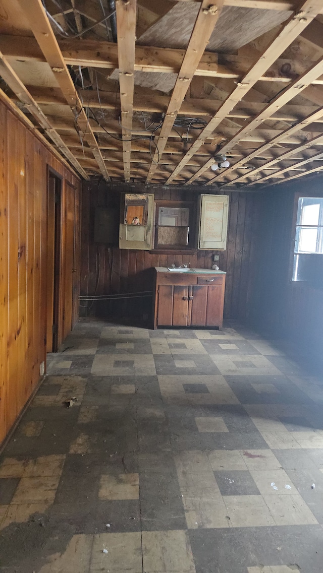 basement featuring wooden walls