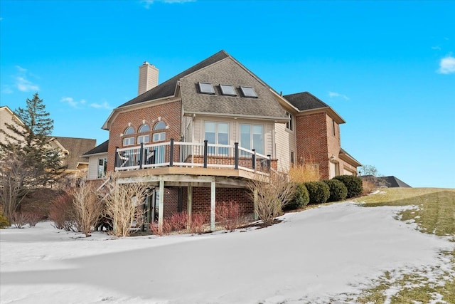 snow covered house with a wooden deck