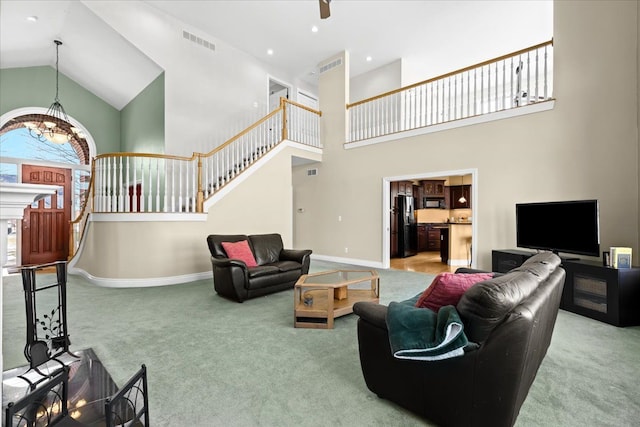 carpeted living room with a towering ceiling and a chandelier