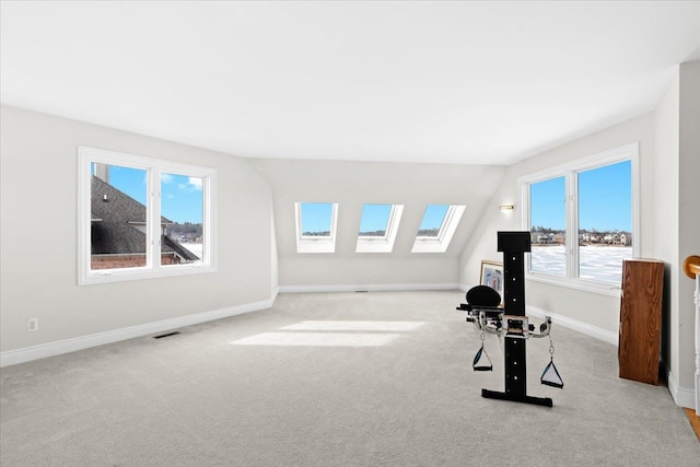 exercise room with light colored carpet and a skylight