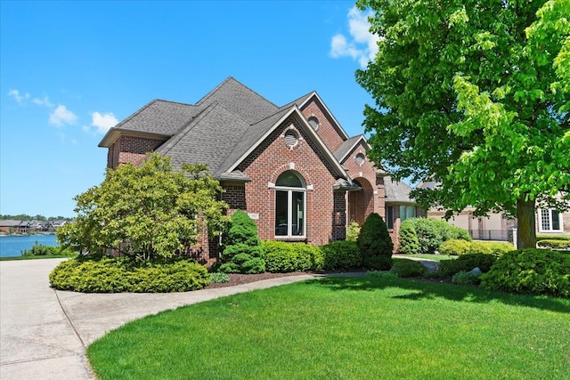 10587 Lighthouse, South Lyon, MI 48178 - view of front of home with brick siding, a front lawn, and a shingled roof