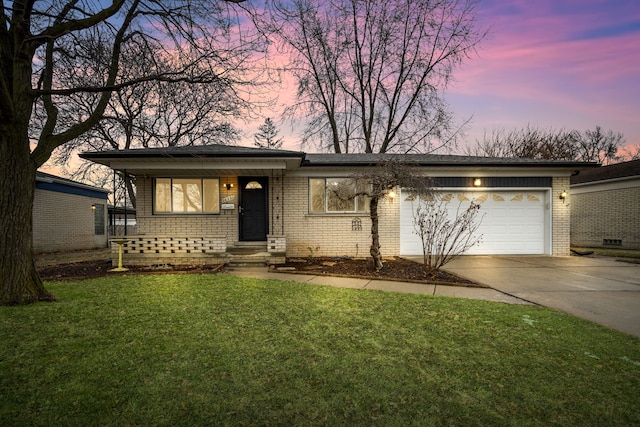 single story home featuring a garage and a lawn