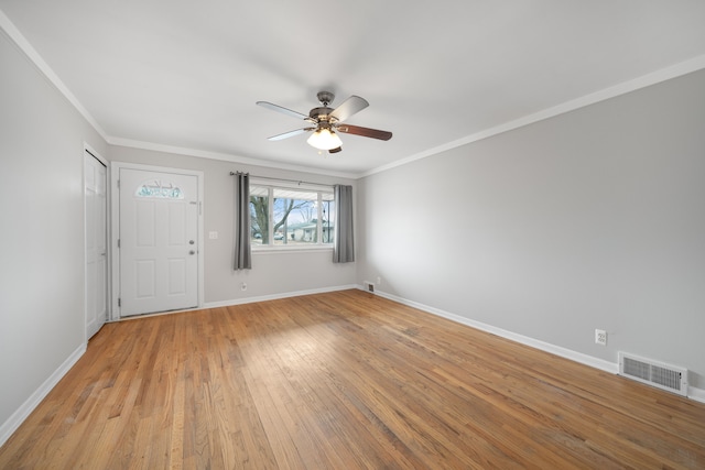 empty room featuring crown molding, ceiling fan, and light wood-type flooring