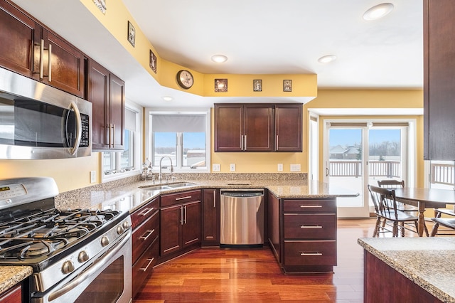 kitchen featuring sink, light stone countertops, a healthy amount of sunlight, and appliances with stainless steel finishes