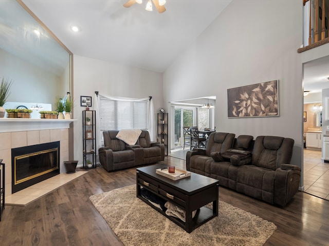 living room with high vaulted ceiling, a fireplace, and hardwood / wood-style floors