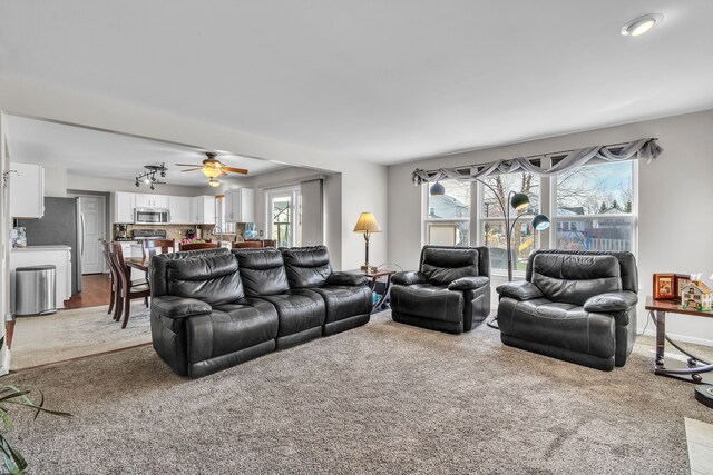 living room with ceiling fan and carpet floors