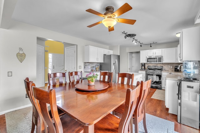 dining room with sink, dark wood-type flooring, and ceiling fan