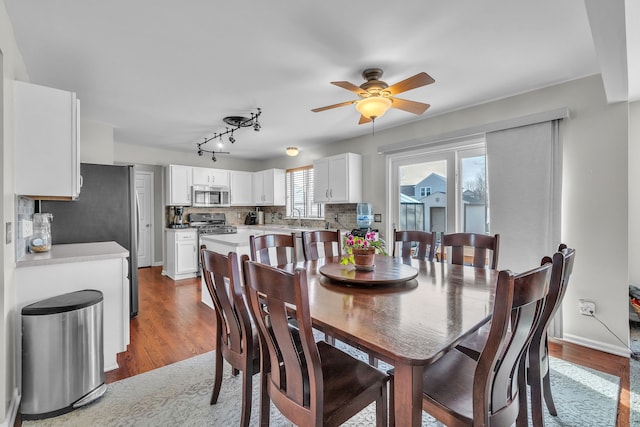 dining space with sink, wood-type flooring, and ceiling fan