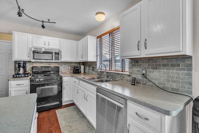 kitchen featuring appliances with stainless steel finishes, sink, white cabinets, and decorative backsplash