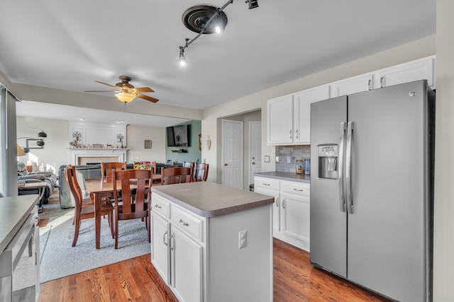 kitchen featuring white cabinetry, a center island, tasteful backsplash, wood-type flooring, and stainless steel fridge with ice dispenser