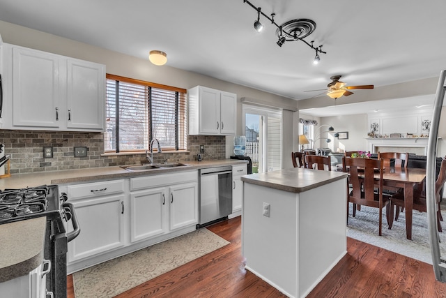 kitchen featuring a kitchen island, white cabinetry, sink, backsplash, and stainless steel dishwasher