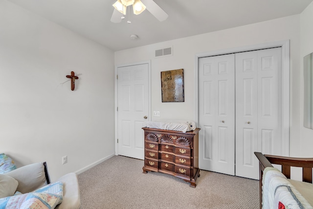 bedroom with light carpet, ceiling fan, and a closet