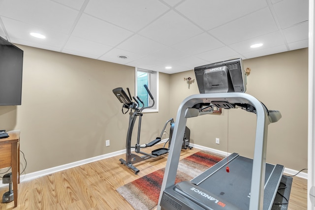 exercise area featuring a paneled ceiling and hardwood / wood-style floors