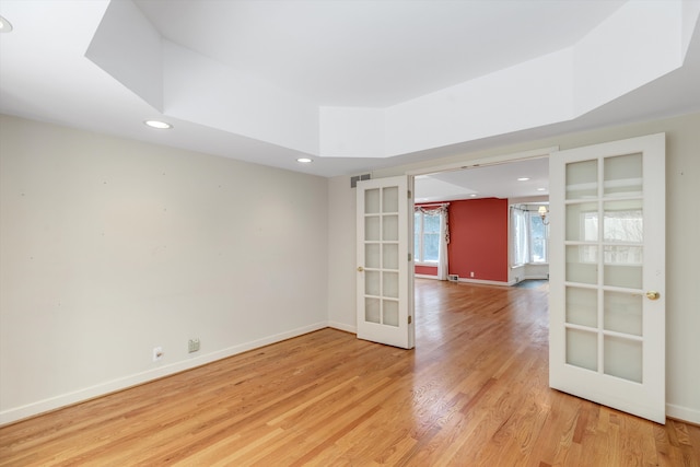 spare room featuring french doors and light hardwood / wood-style floors